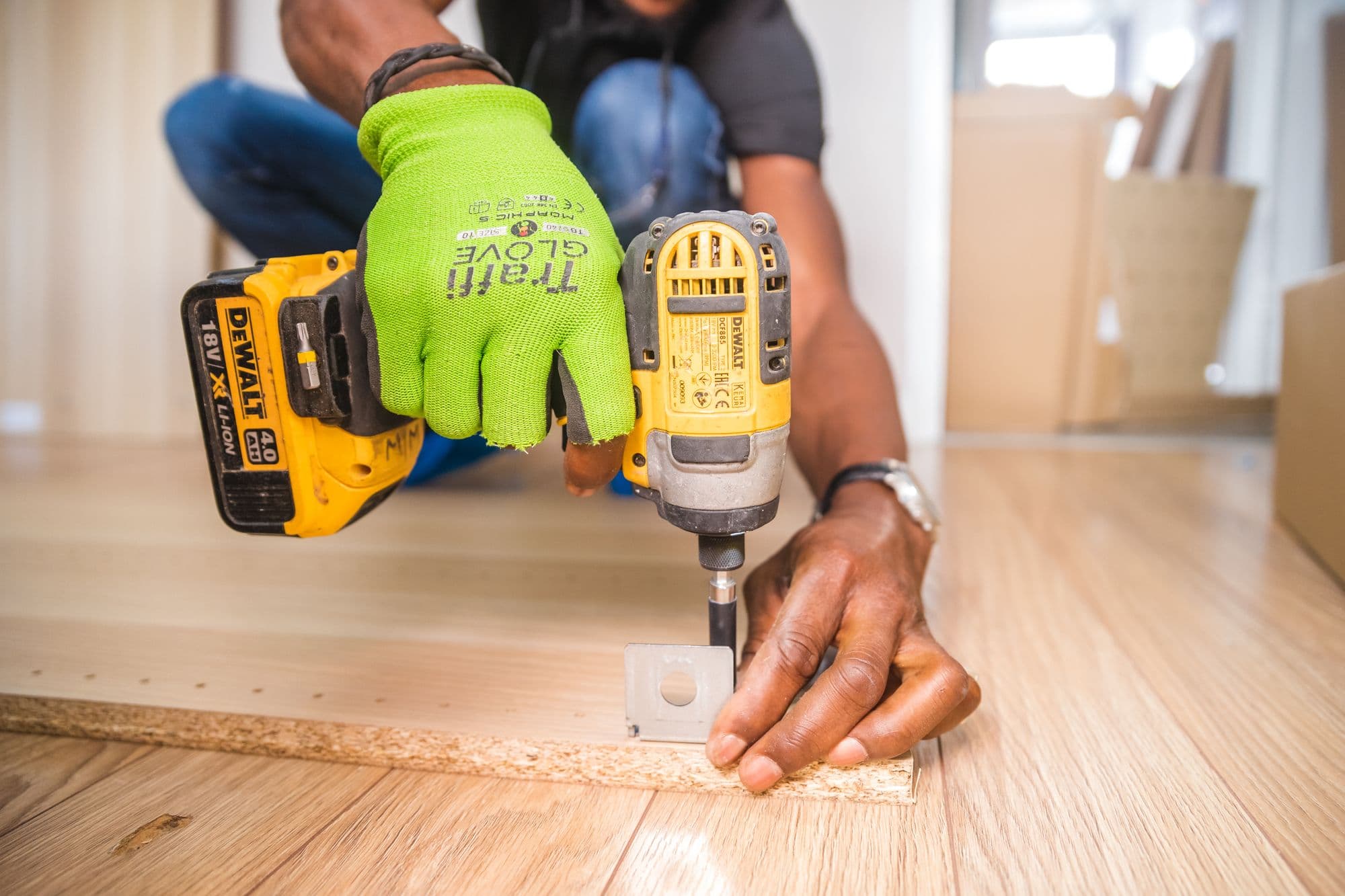 Pose d'un parquet, perceuse en main.